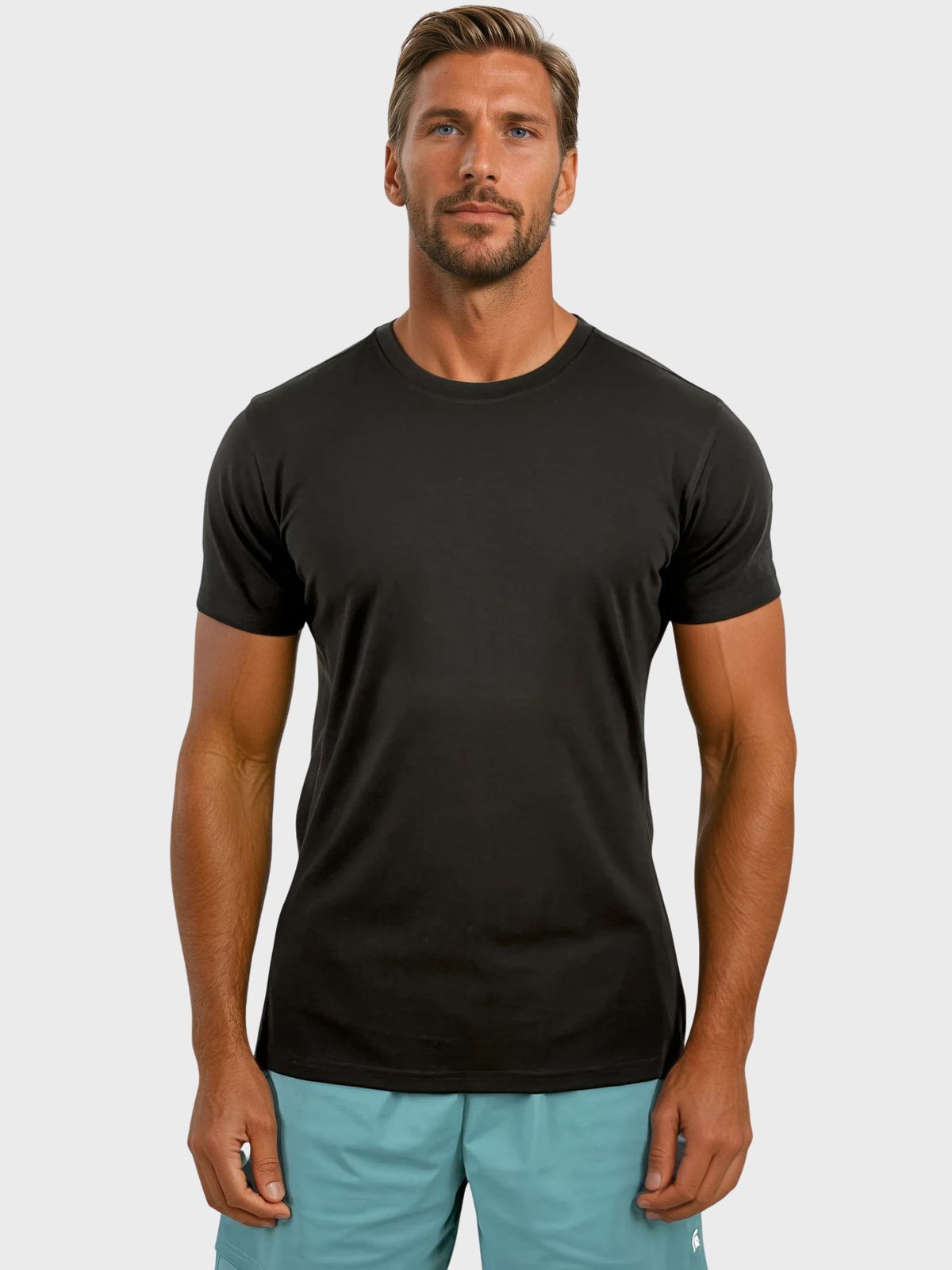 Man wearing a black t-shirt and light blue shorts on a white background