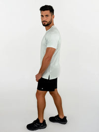 Man wearing a light gray t-shirt and black shorts on a white background