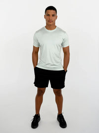 Person wearing a light gray t-shirt and black shorts on a white background