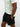 Person wearing black shorts and a white shirt on a plain background